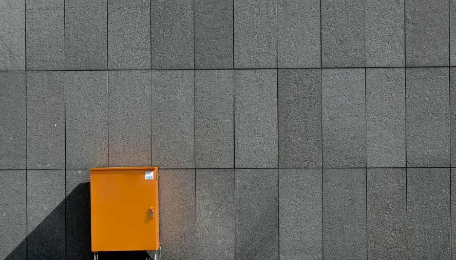 Orange locker against a grey wall.
