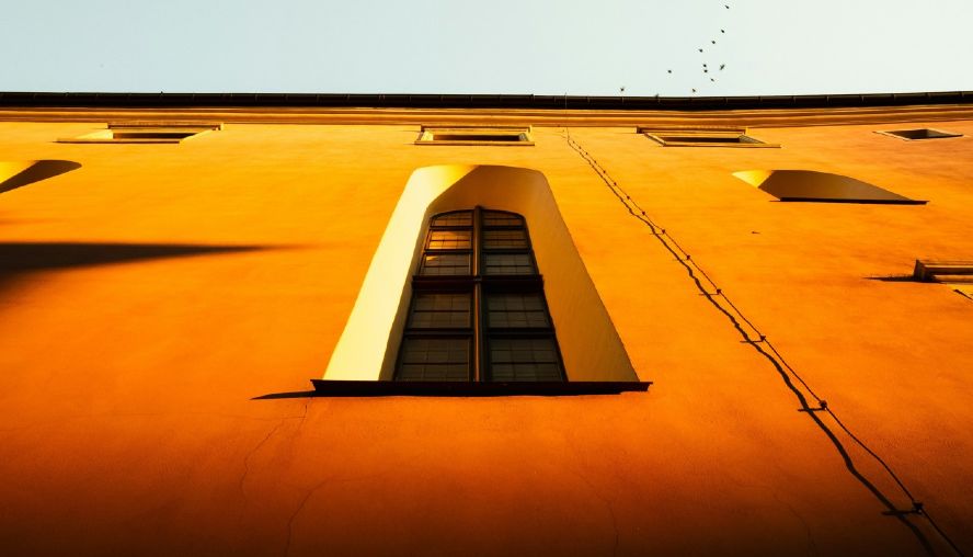 Looking up at a large window in an orange building