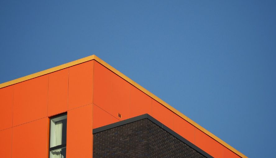 Top of orange building with clear blue sky behind